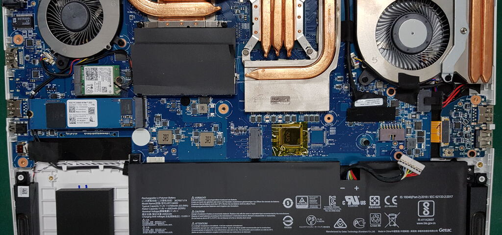 Conserto de placa-mãe de notebook em Porto Alegre, mostrando interior do laptop com dissipadores de calor, coolers e componentes eletrônicos em manutenção técnica especializada