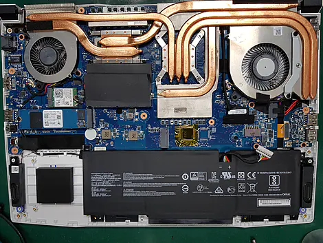 Conserto de placa-mãe de notebook em Porto Alegre, mostrando interior do laptop com dissipadores de calor, coolers e componentes eletrônicos em manutenção técnica especializada
